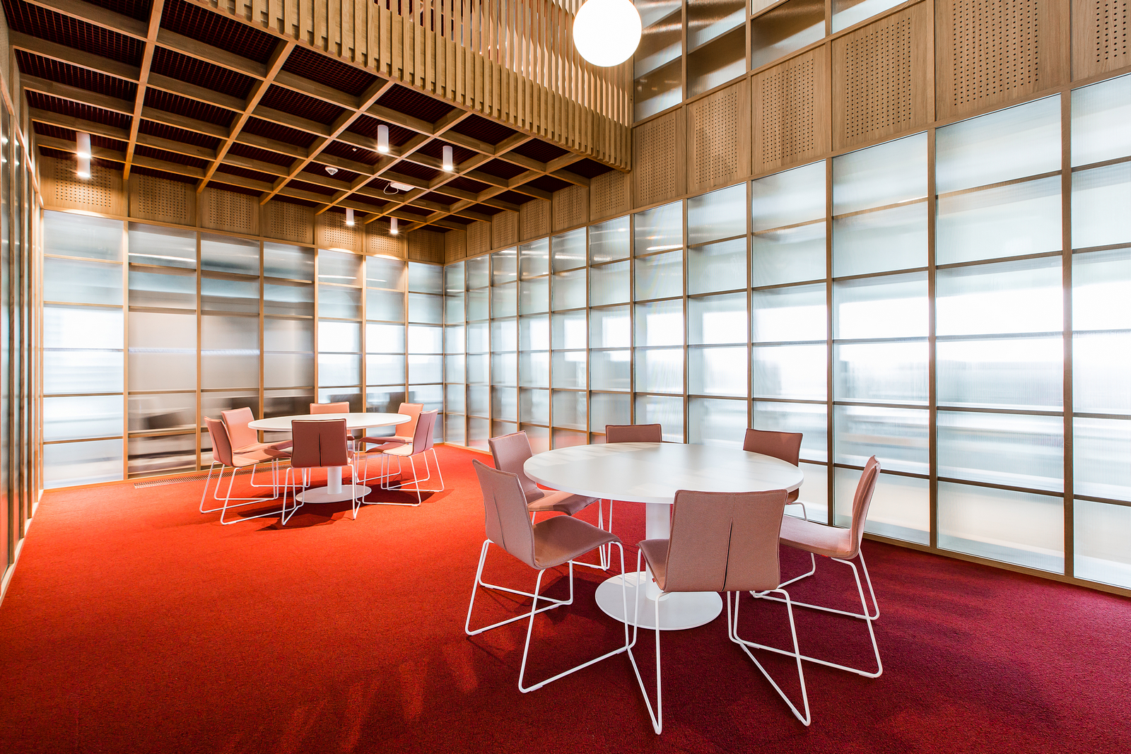 Brainstormruimte met rood tapijt, witte systemtafels en One stoelen