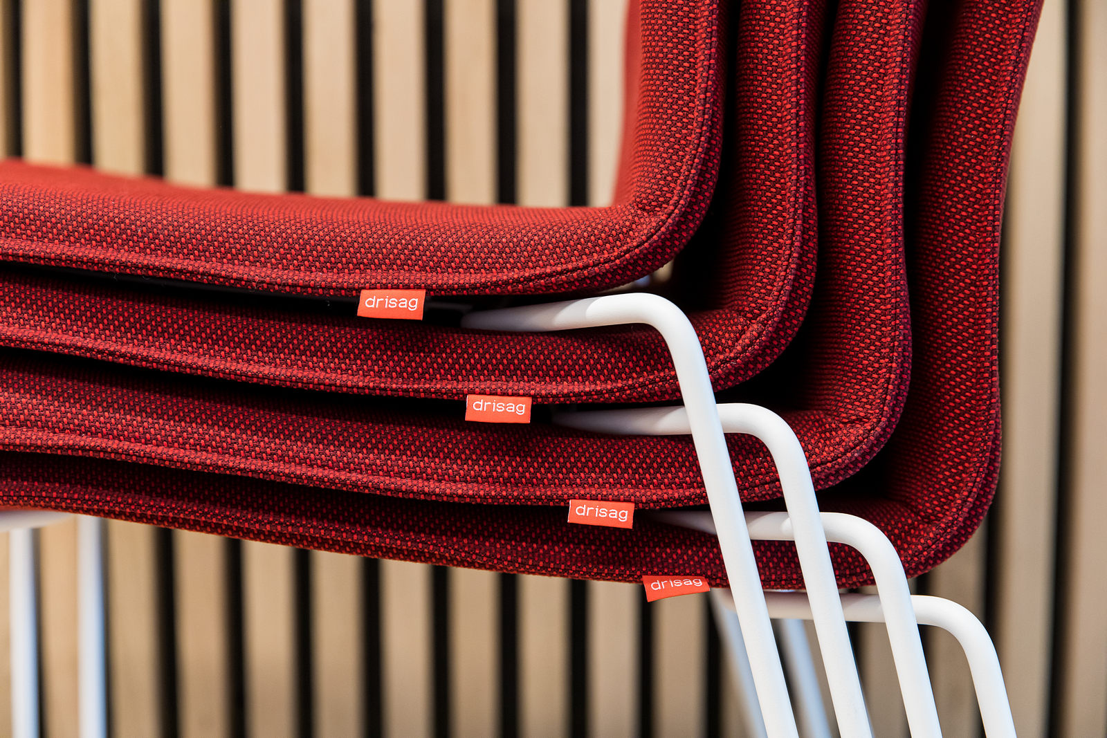 Detailfoto van Rode One stoelen met witte poten en het Drisag label